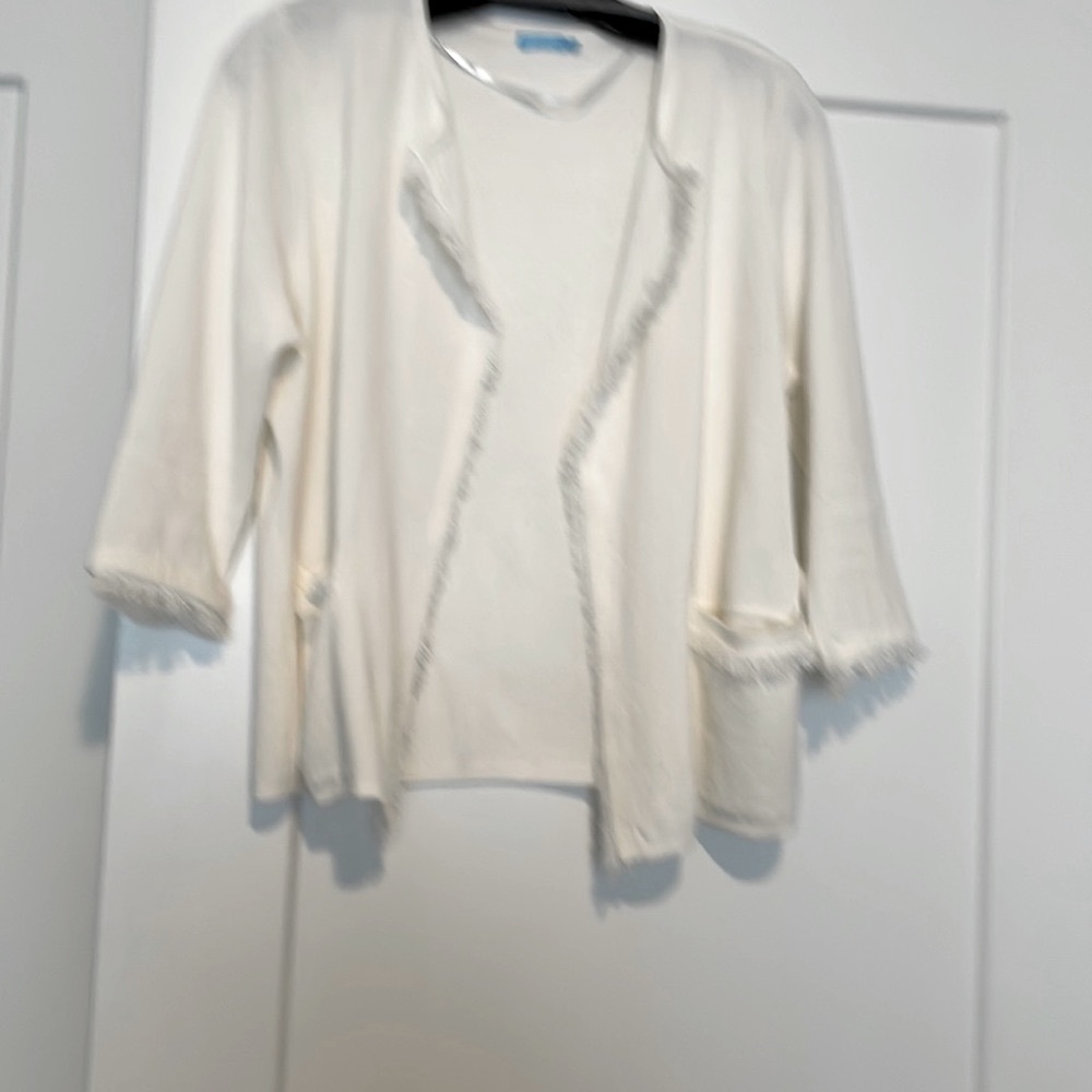 Short white knit jacket sweater fringe accents. Two pockets in front